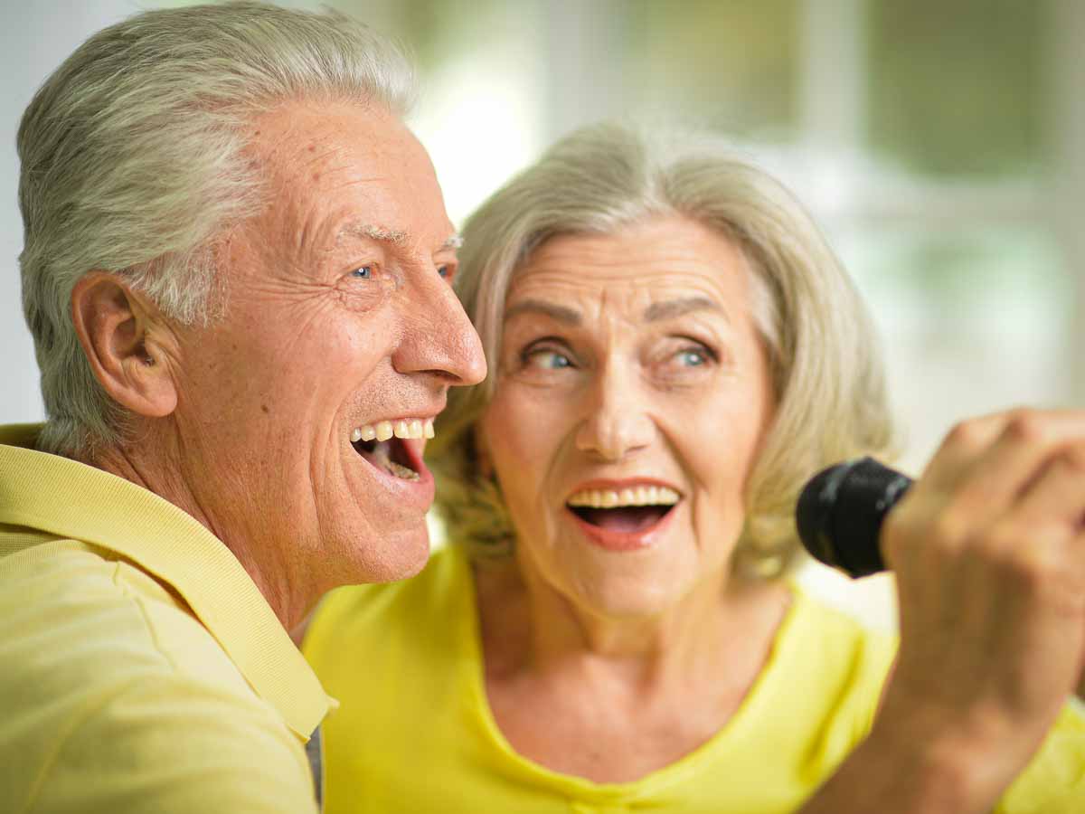 Zwei Senioren singen mit Mikrofon